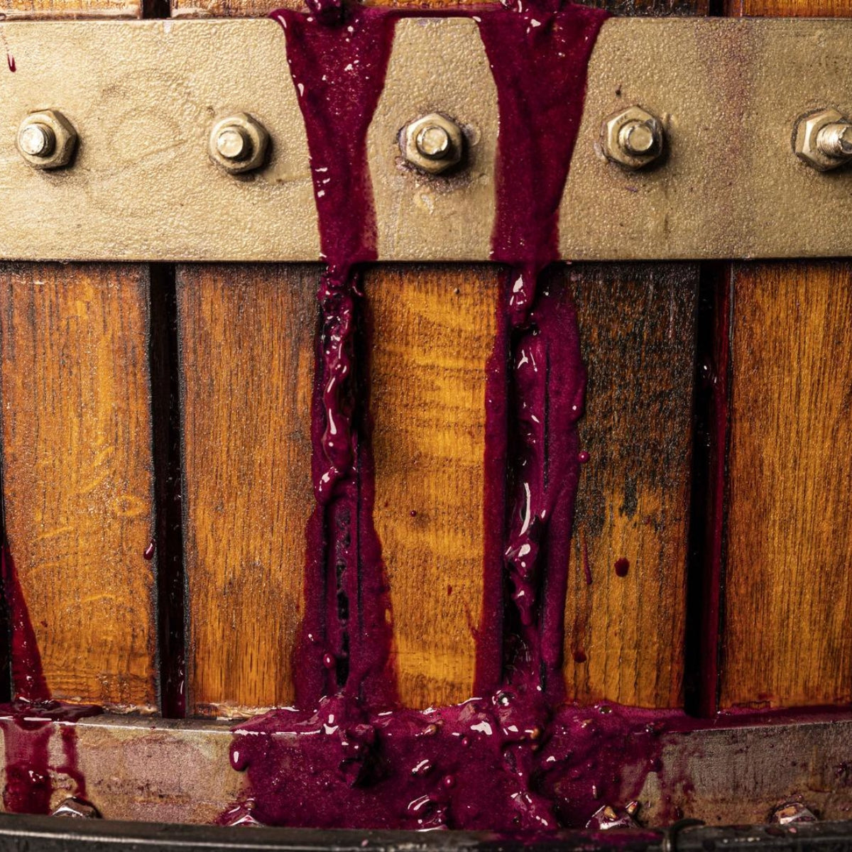 Close-up of a wooden press with purple juice dripping from it at the Greenock Creek winery in the Barossa Valley