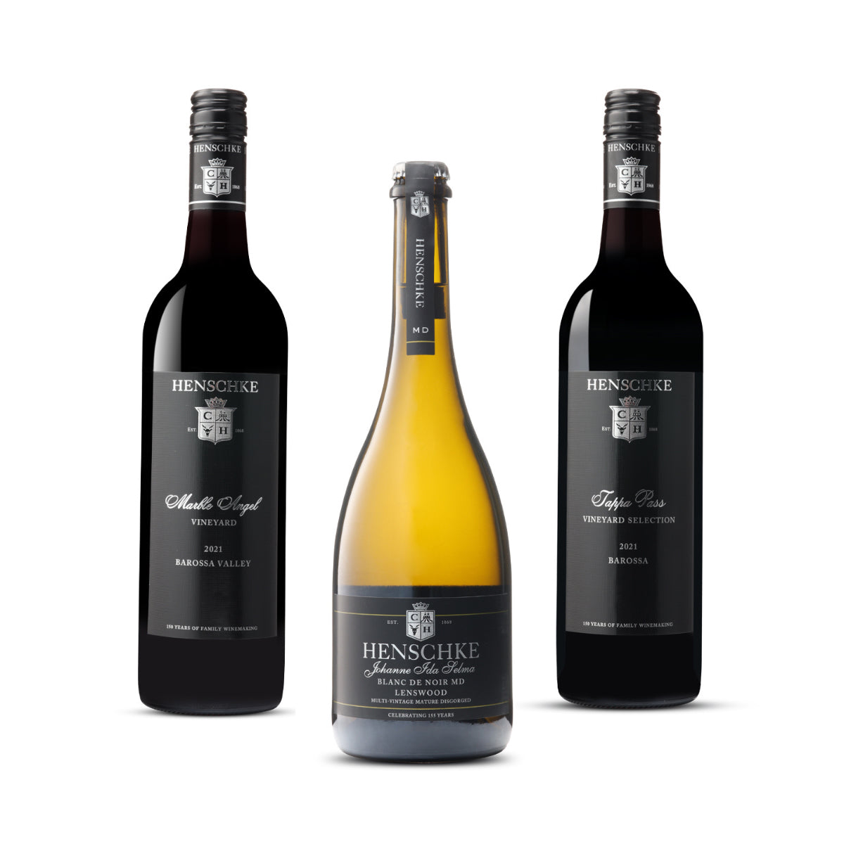 Image displaying three bottles of wine from Henschke. From left to right: Tappa Pass Shiraz 2021 from the Barossa Valley, Henschke Sparkling Johann’s Garden Blanc de Noir MD Lenswood, and Marble Angel Cabernet Sauvignon 2021 from the Barossa Valley."